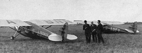 Two of the de Havilland dH.80a Puss Moths owned by the Prince of Wales and resplendent in his colour scheme, red upper fuselage and blue lower, with a red stripe up the centre of an all blue fin and rudder.