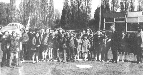 Tom Howard, standing to the right, shows a group of local school children the signal square and explains what the symbols mean to pilots. Despite his other business pressures, Tom took a personal interest in the school and charter companies, and was often to be found at the aerodrome.